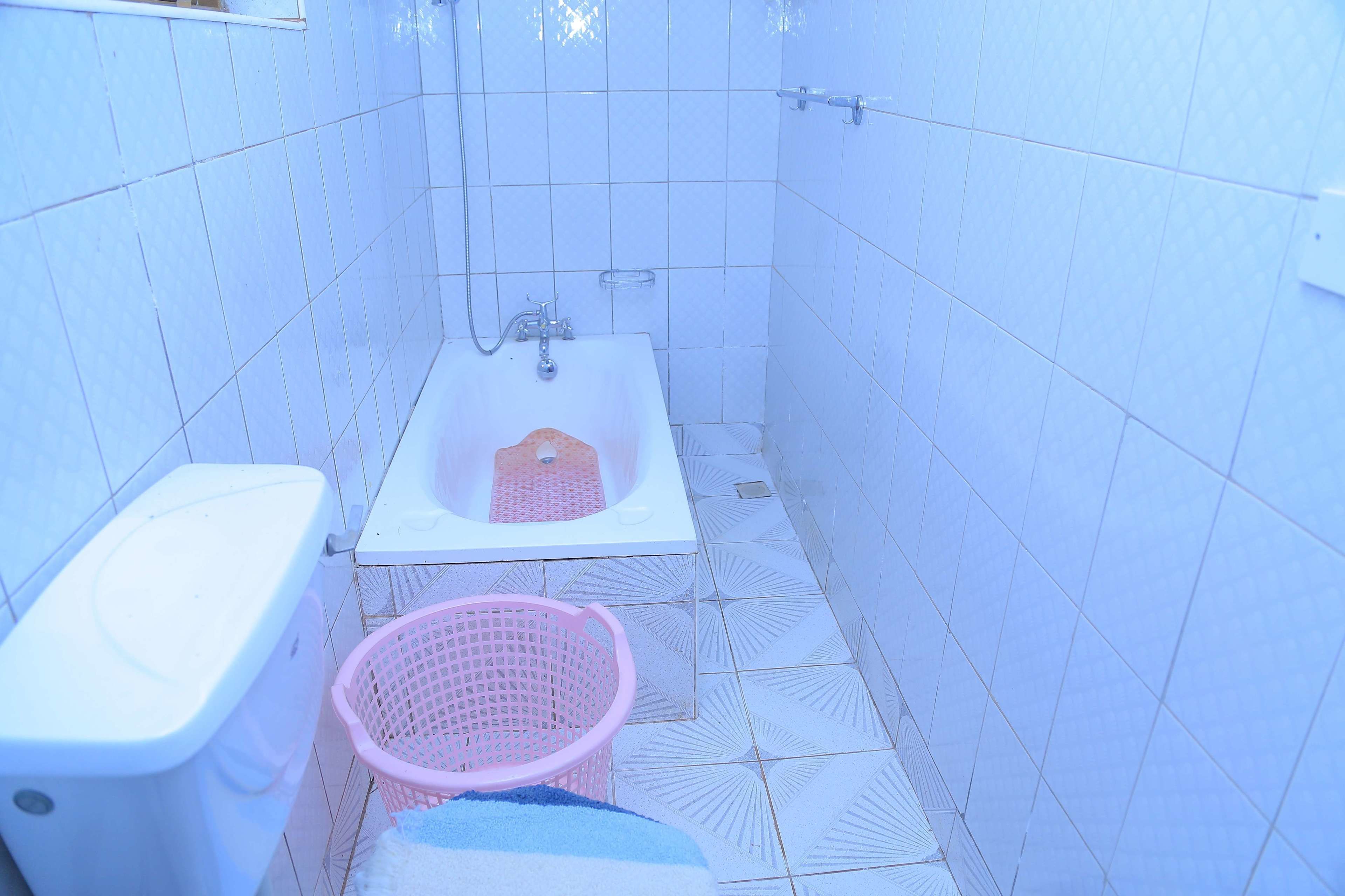 A small bathroom with a toilet, sink, and shower.