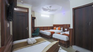 Une chambre d’hôtel avec deux lits, un bureau et une chaise.