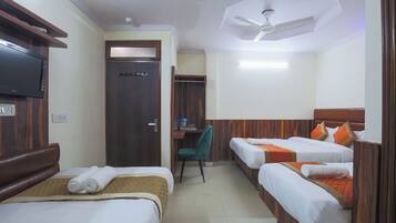A hotel room with two beds, a desk, a chair, and a television.