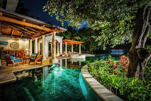 A pool area with a covered seating area, a stone structure, and lush greenery. - Rare Find! Beachfront Villa w/ Private Pool, Hot Tub, Sauna & Breakfast Services (Tamarindo)
