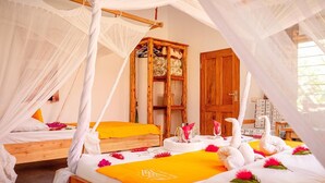 Una habitación con una cama bajo un dosel, un armario de madera y una mesita con adornos.