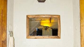 A bathroom with a wooden vanity, a mirror, and a sink.