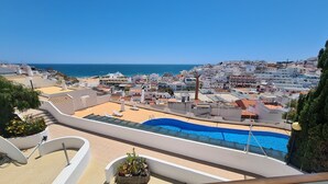 A rooftop pool with a view of a coastal town and the sea. - Albufeira Sea view (51) (Albufeira)