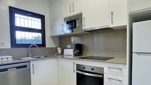 Una cucina moderna con elettrodomestici in acciaio inossidabile, una finestra e mobili bianchi.