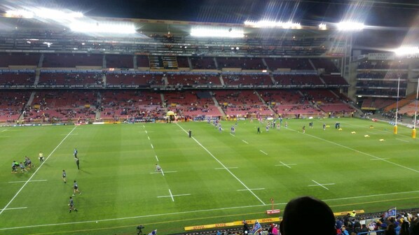A stadium with multiple tiers of seating and a well-maintained grass field.