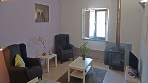 Una sala de estar con sofá, sillón, mesa de centro y chimenea.