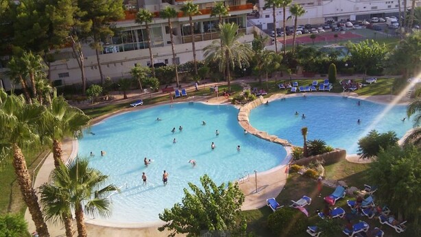 A resort with two large swimming pools surrounded by palm trees and lounge chairs. - Gemelos 22 Apartments (Benidorm)