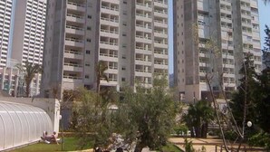 A high-rise residential building with multiple balconies, a modern architectural design, and a clear sky in the background. - Gemelos 22 Apartments (Benidorm)
