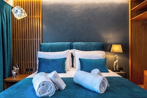 Ein Hotelzimmer mit Bett, Kissen und einem Nachttisch mit Lampe.