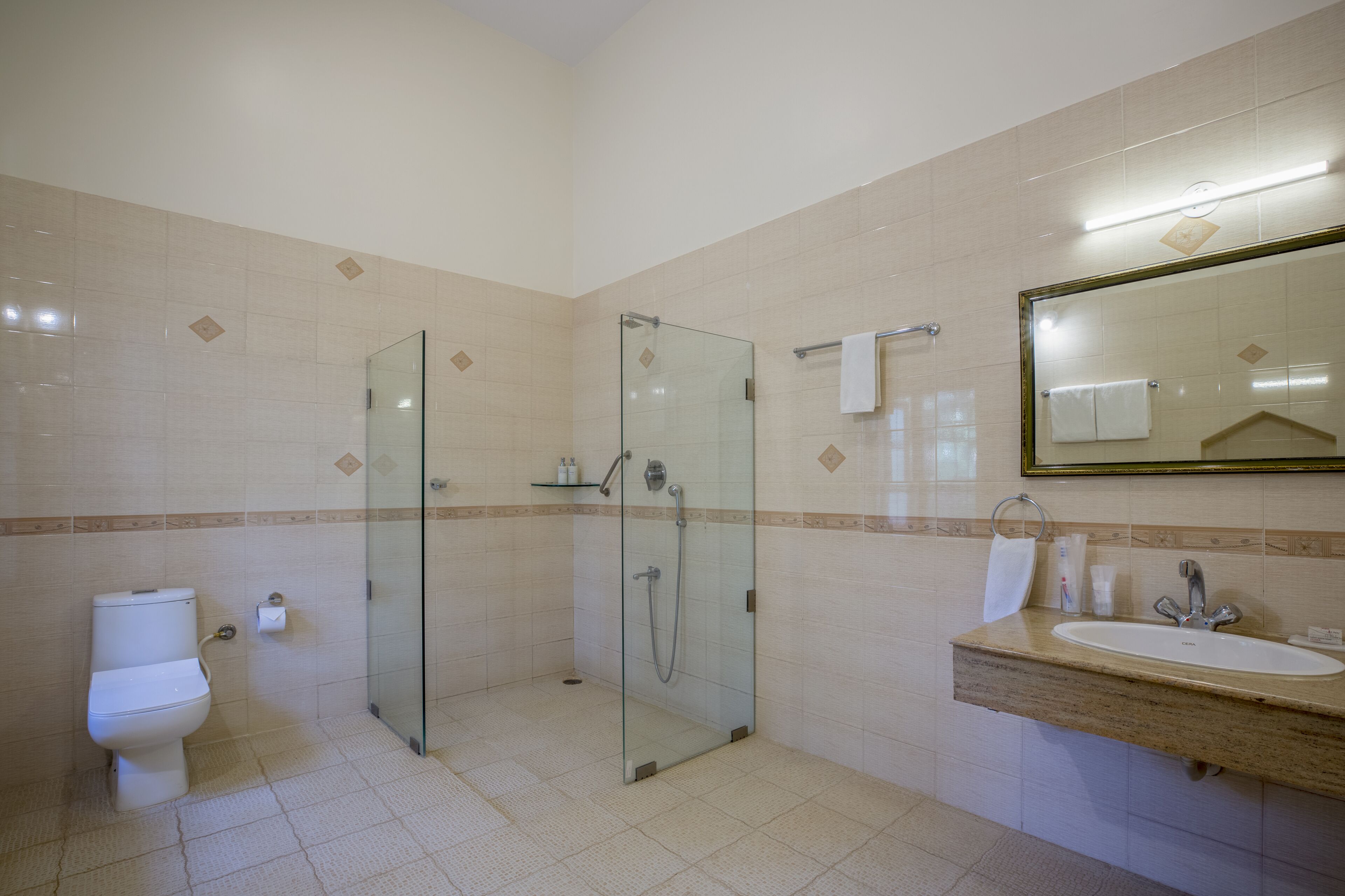 Ein Badezimmer mit Duschkabine, Toilette und Waschbecken mit Spiegel.