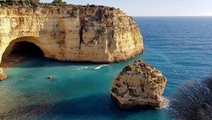 A coastal cliff with a natural cave entrance and clear turquoise waters. - Albufeira, with terrace, sea views, 5 min to beach (21) (Albufeira)