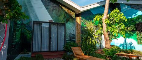 A modern house with a stone pathway leading to a wooden bench and a glass door.