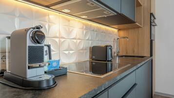 A modern kitchen with a coffee machine, a toaster, and a sink.