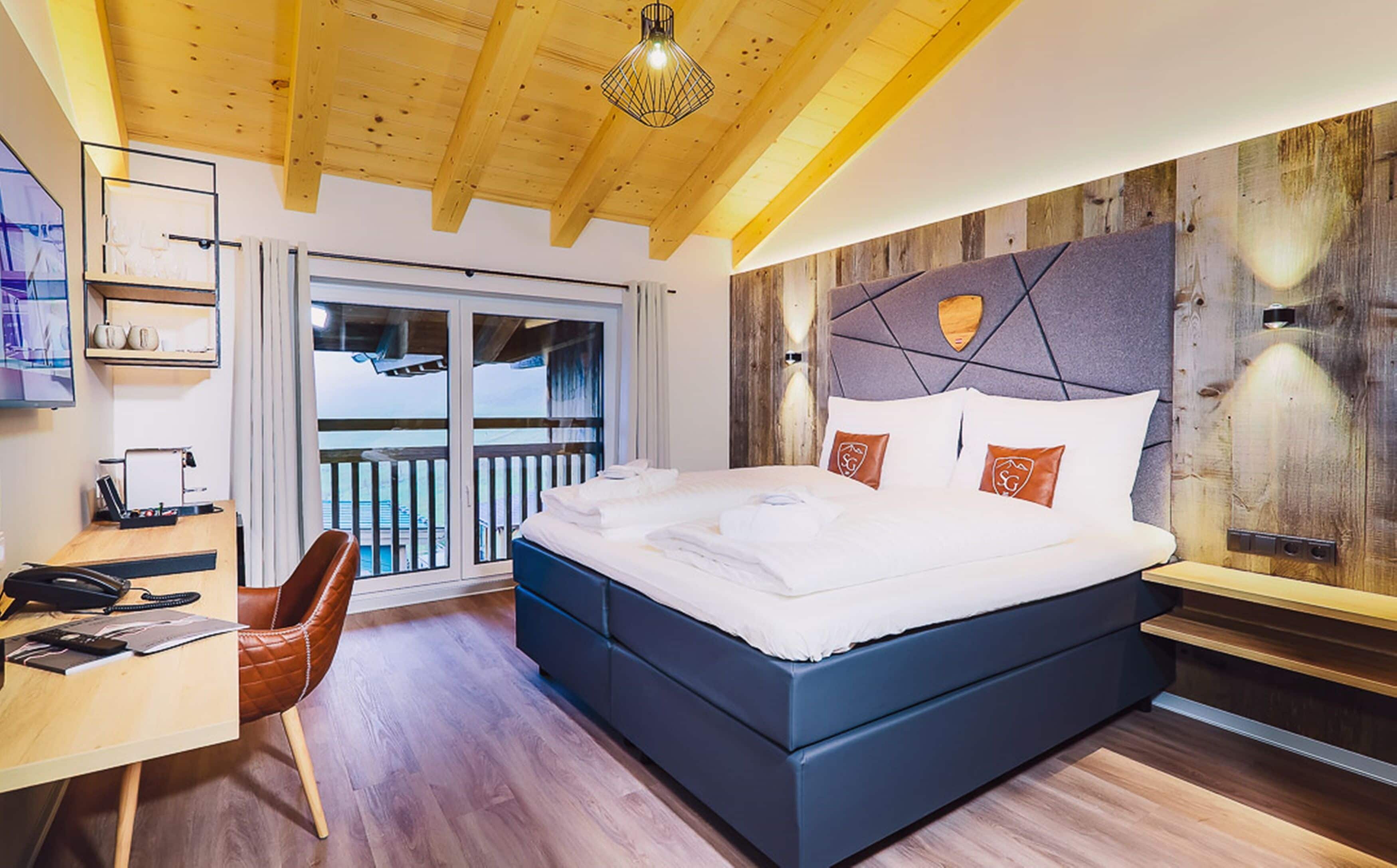 Un dormitorio moderno con una cama grande, techo de madera y vistas al balcón.