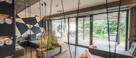 A modern spa area with a geometric wall design, seating, and a view of the outdoors.