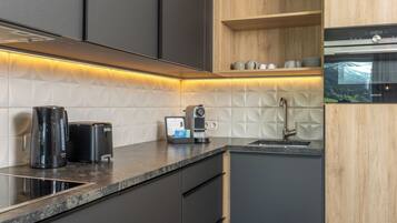 A modern kitchen with a built-in oven, a coffee maker, and a toaster on the countertop.
