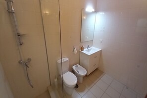 A bathroom with a glass shower enclosure, a toilet, a bidet, and a sink with a mirror. - Adults Only - Monte Horizonte Casa Sobreiro Eco & Nature (Santiago do Cacém)