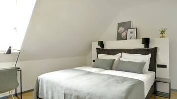 A bedroom with a bed, a desk, and a chair.