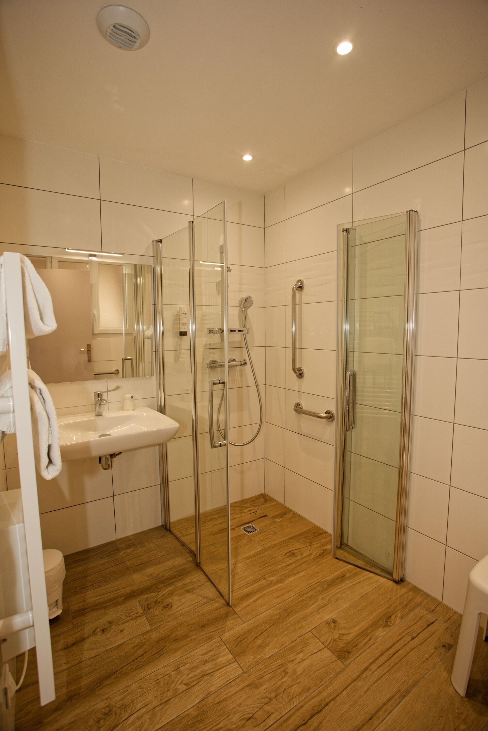 Une salle de bain moderne dotée d’une douche à parois de verre, d’un lavabo et de toilettes.