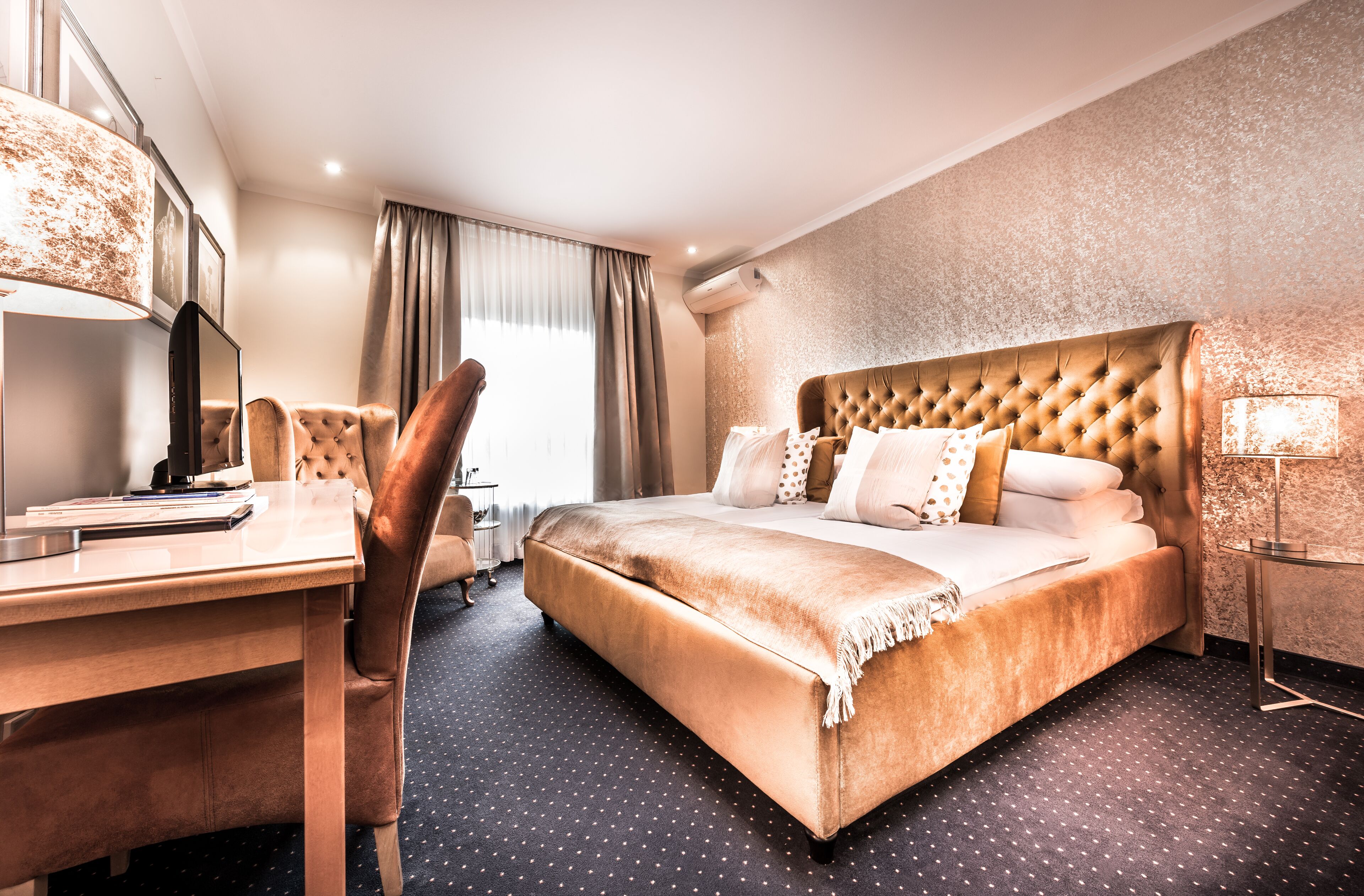 Une chambre d’hôtel avec un grand lit, un bureau et une chaise.
