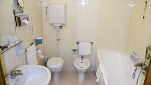 Un baño con lavamanos, inodoro, bidé y bañera.