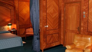 Una habitación con cama, una silla y un armario.