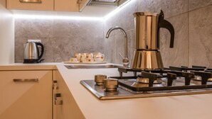Une cuisine moderne équipée d’une cuisinière à gaz, d’une machine à café et d’un évier.