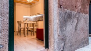 Une cuisine moderne avec des meubles en bois, un coin repas avec des chaises et un banc rouge.