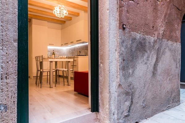 Une cuisine moderne avec des meubles en bois, un coin repas avec des chaises et un banc rouge.