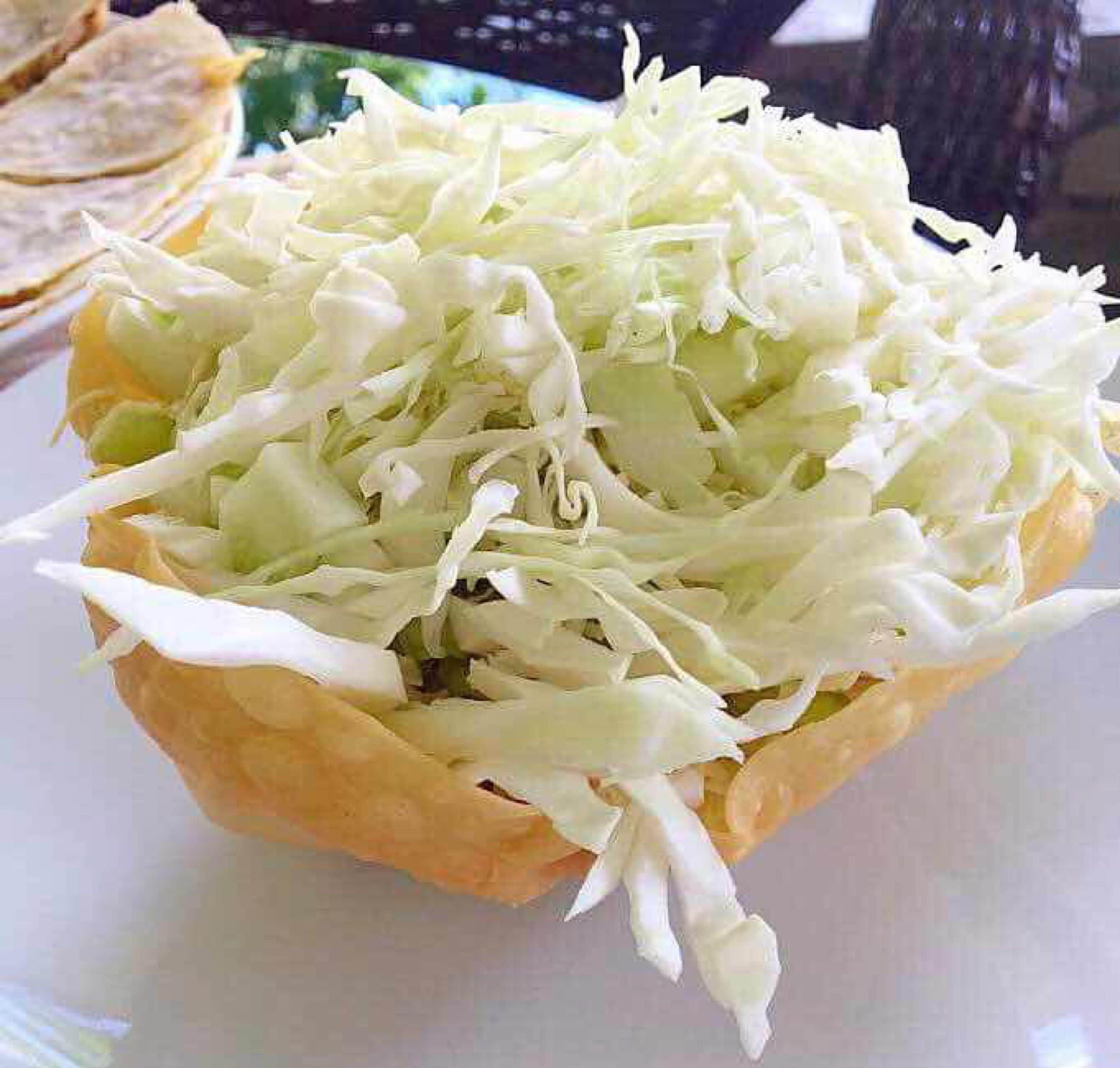 A sandwich with shredded lettuce on a white plate.