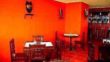 Un ristorante con pareti rosse, tavoli e sedie in legno.