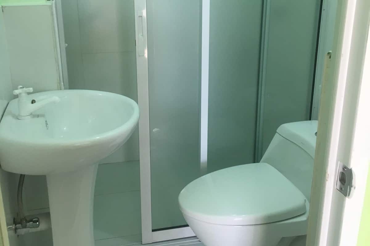 A bathroom with a white sink, toilet, and a glass-enclosed shower area.