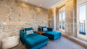 A cozy room with stone walls, a large window, and blue furniture.