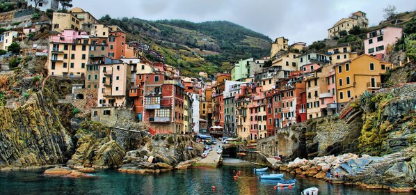 A coastal village with colorful buildings, a narrow waterway, and boats. - Affittacamere Casa Lorelei (Riomaggiore)
