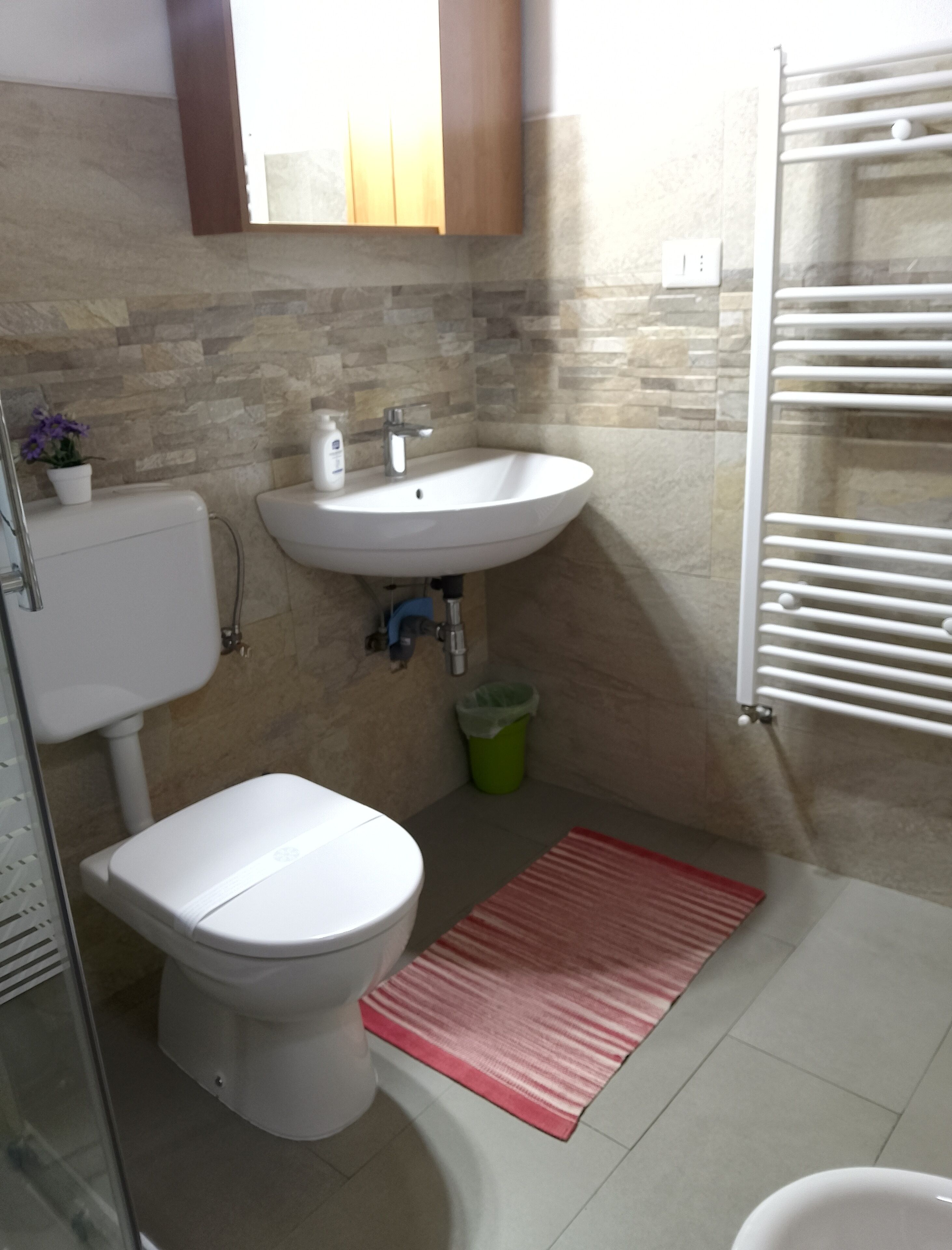 Une salle de bain comprenant des toilettes, un lavabo et un espace douche.
