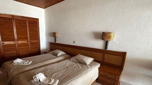 A hotel room with two beds, wooden headboards, a large wardrobe, and two wall-mounted lamps. - Albufeira, Ocean terrace (22) (Albufeira)