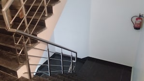 A staircase with metal railings and a fire extinguisher mounted on the wall.