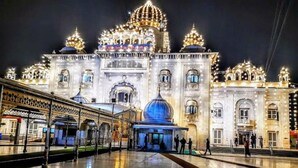 A grand, illuminated building with multiple domes and arches, likely a historical or cultural landmark.