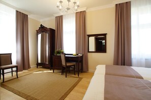 A hotel room with a large bed, a desk with a chair, a mirror, and a chandelier. - Villa La Pierre (Strzegom)