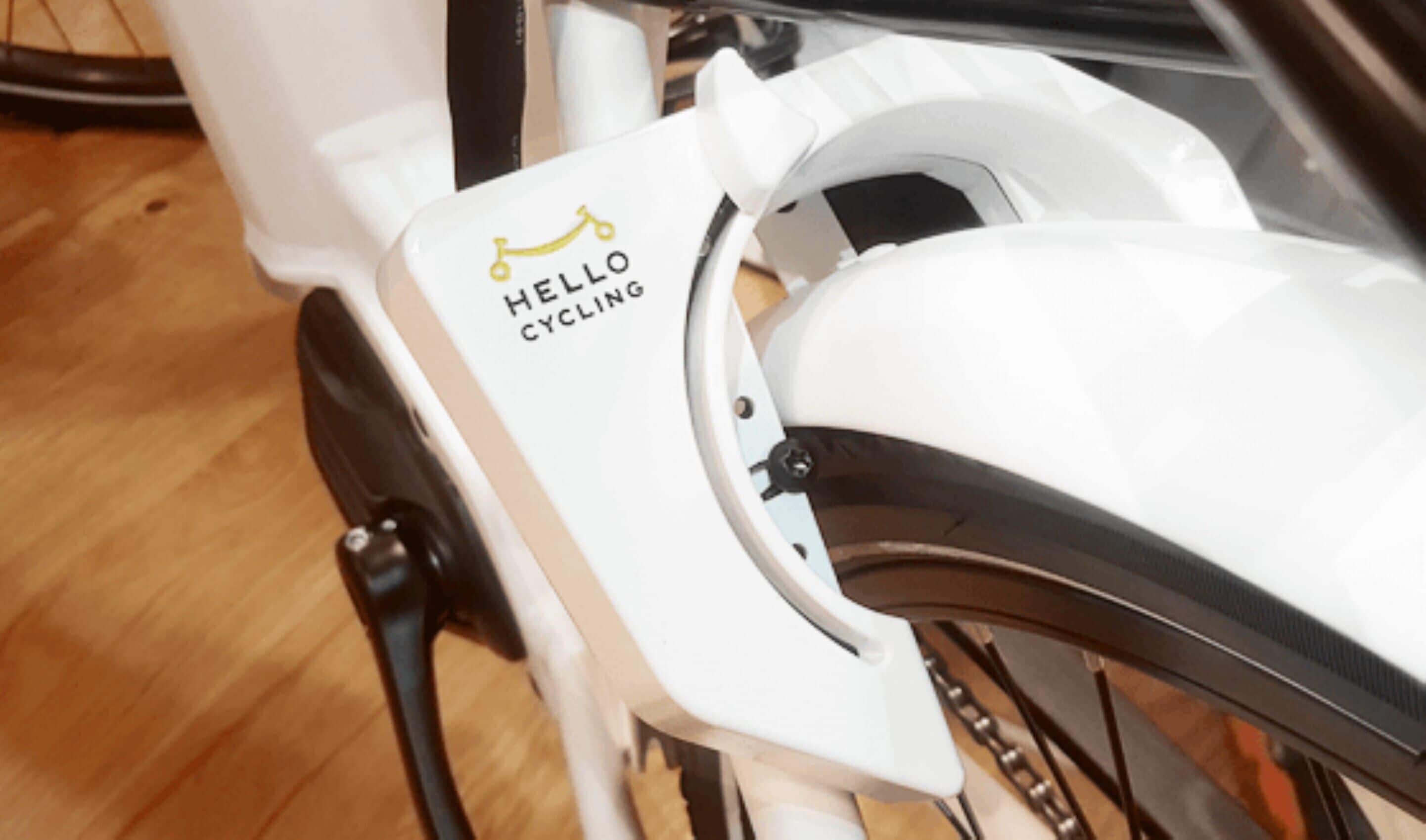 A close-up of a white bicycle with a "HELLO CYCLING" decal on the frame.