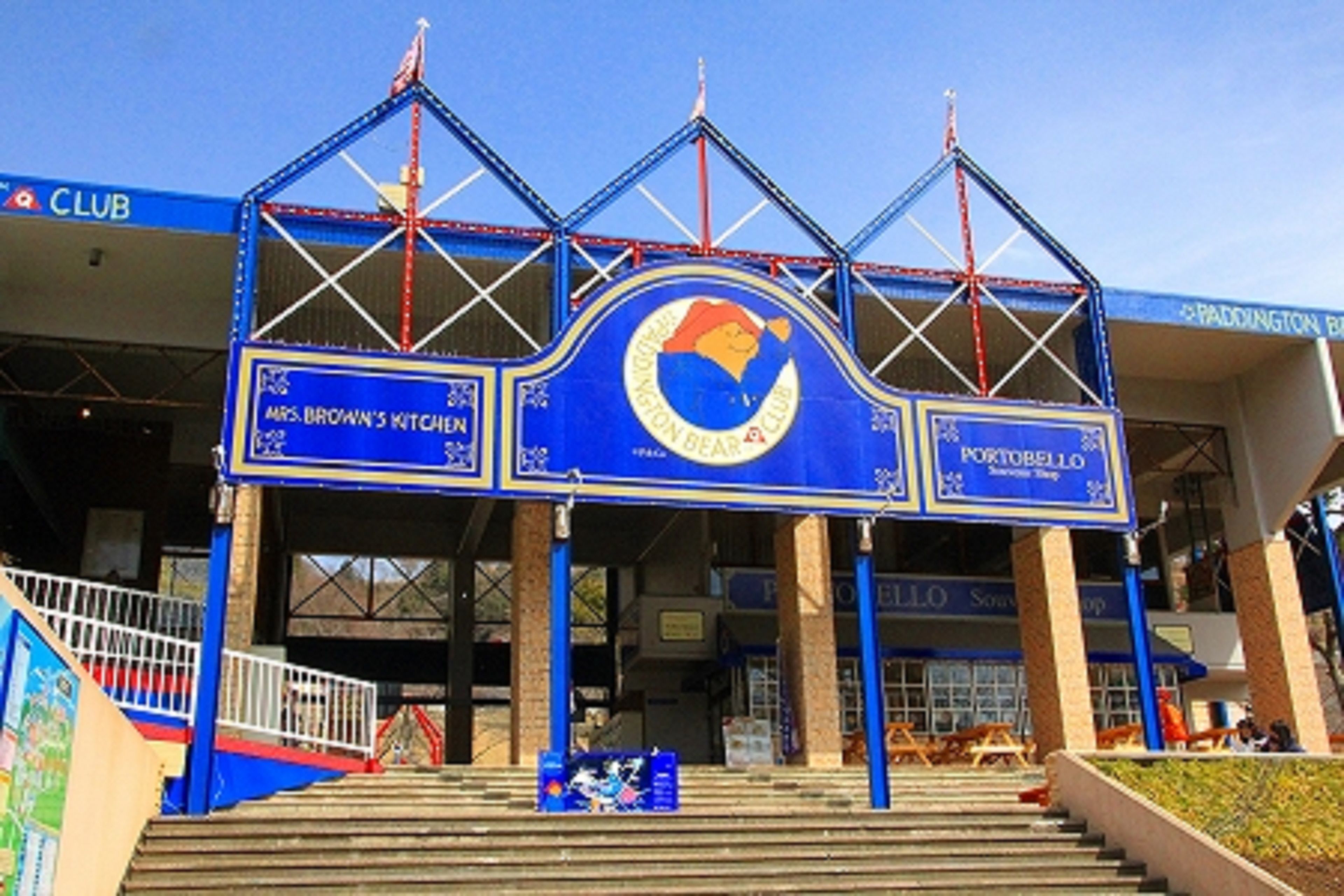 A building entrance with a blue and white color scheme, featuring a sign for 'Portobello' and 'Mrs. Brown's Kitchen'.