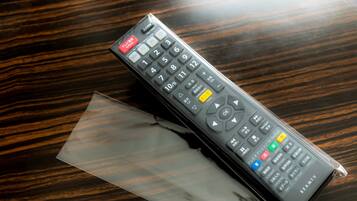 A remote control on a wooden surface.