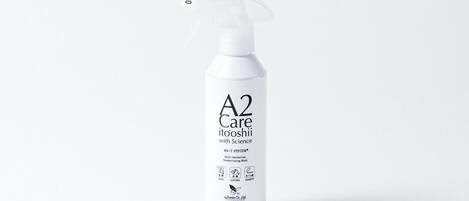 Une bouteille blanche portant l’étiquette « A2 Care » et munie d’un embout pulvérisateur, ce qui indique qu’il s’agit d’un spray désodorisant.