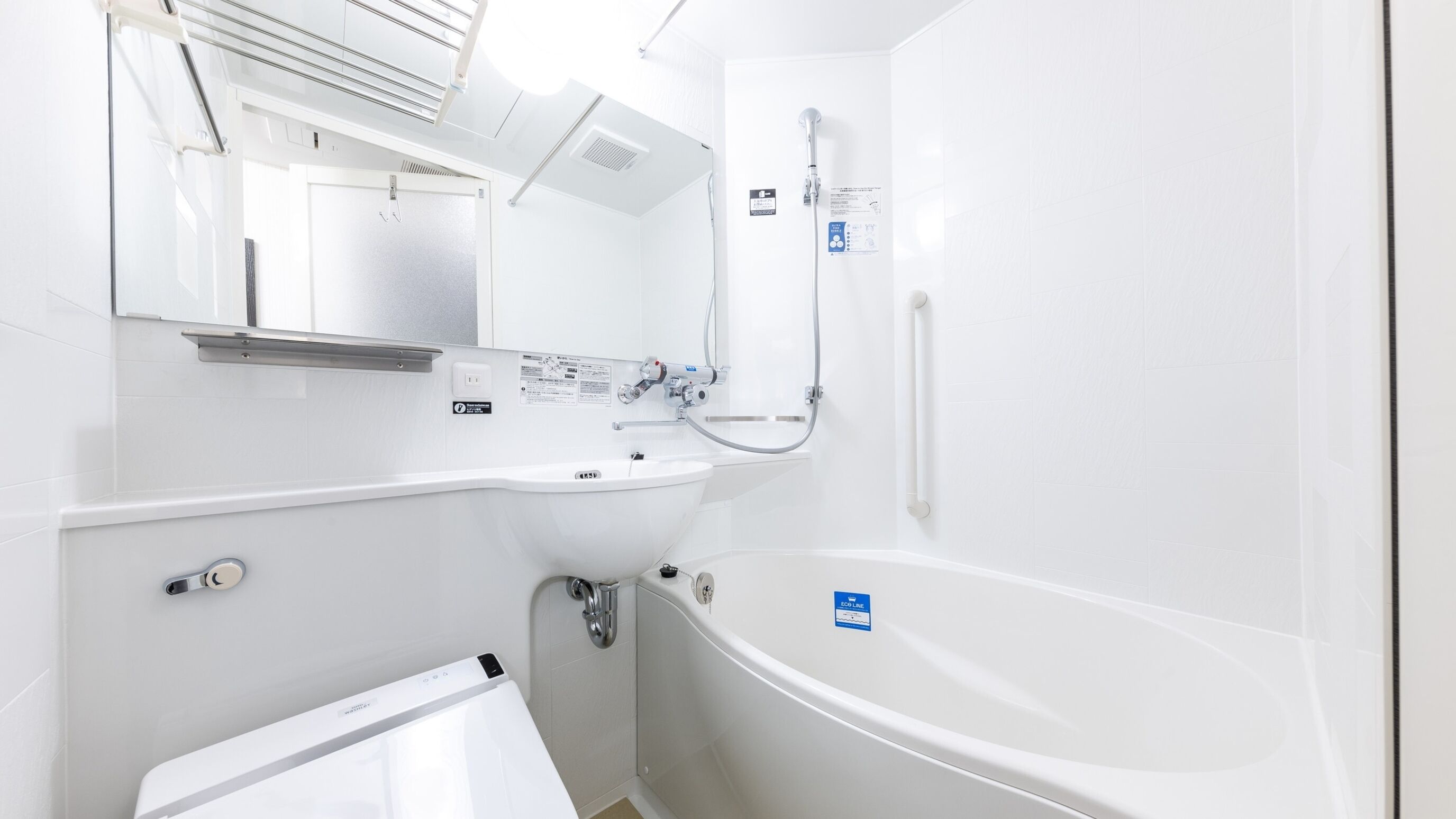Ein modernes Badezimmer mit einem weißen Waschbecken, Spiegel und Badewanne.