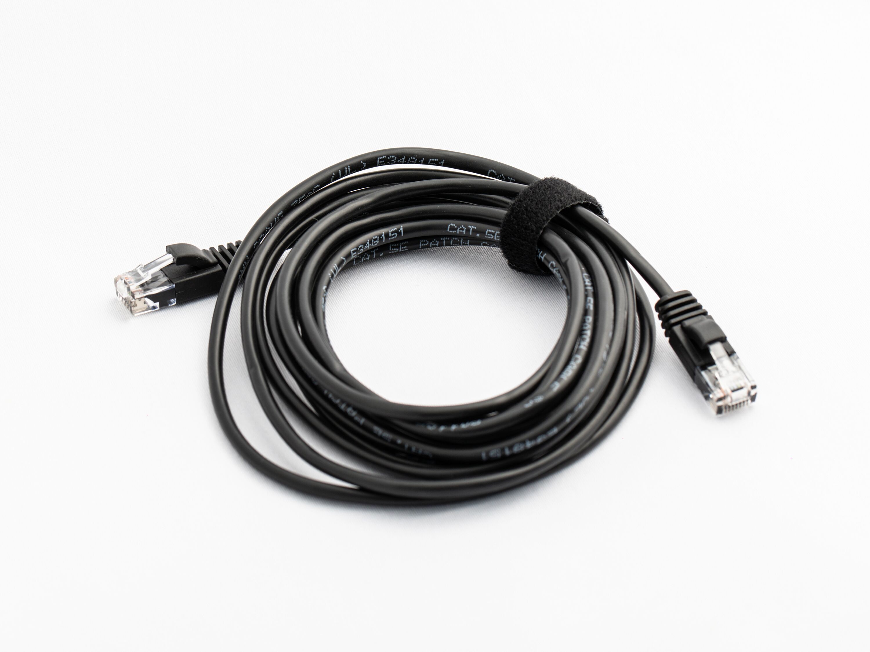 Un cable negre amb connectors RJ45 a ambdós extrems.