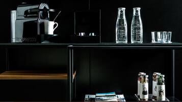 Eine moderne Küche mit einer Kaffeemaschine, zwei Glasflaschen und einigen Gläsern auf der Arbeitsplatte.