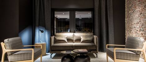 A modern living room with a sofa, two armchairs, and a coffee table.