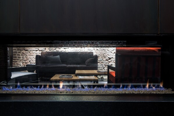 Una sala de estar acogedora con chimenea, un sofá y una mesa de centro.
