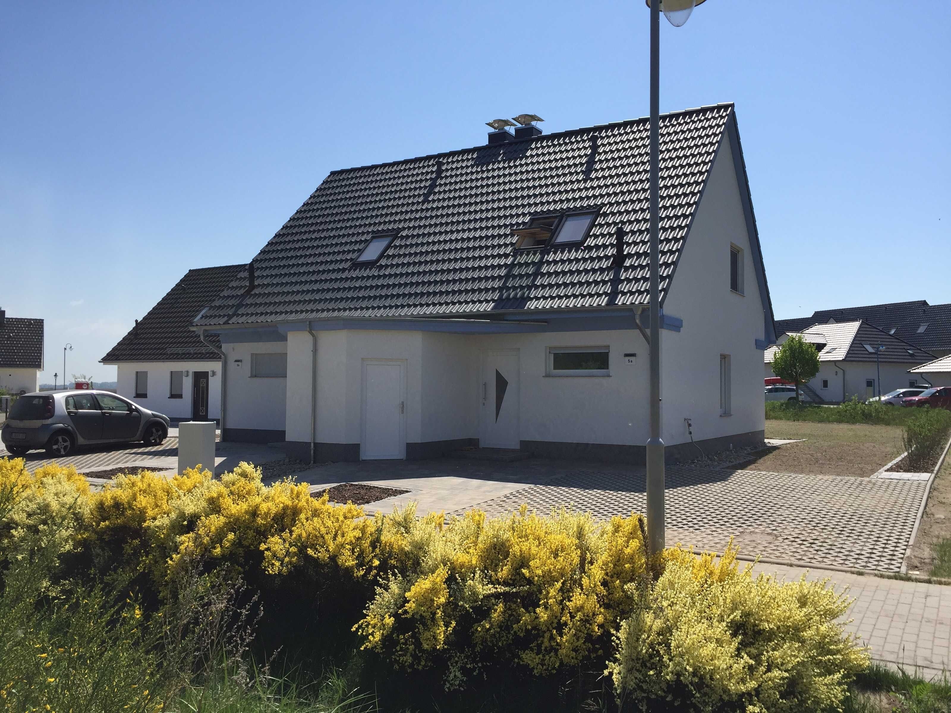 Een woongebouw met een schuin dak, een deur en een klein raam.