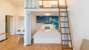 Een slaapkamer met een stapelbed, een bureau en een ladder.